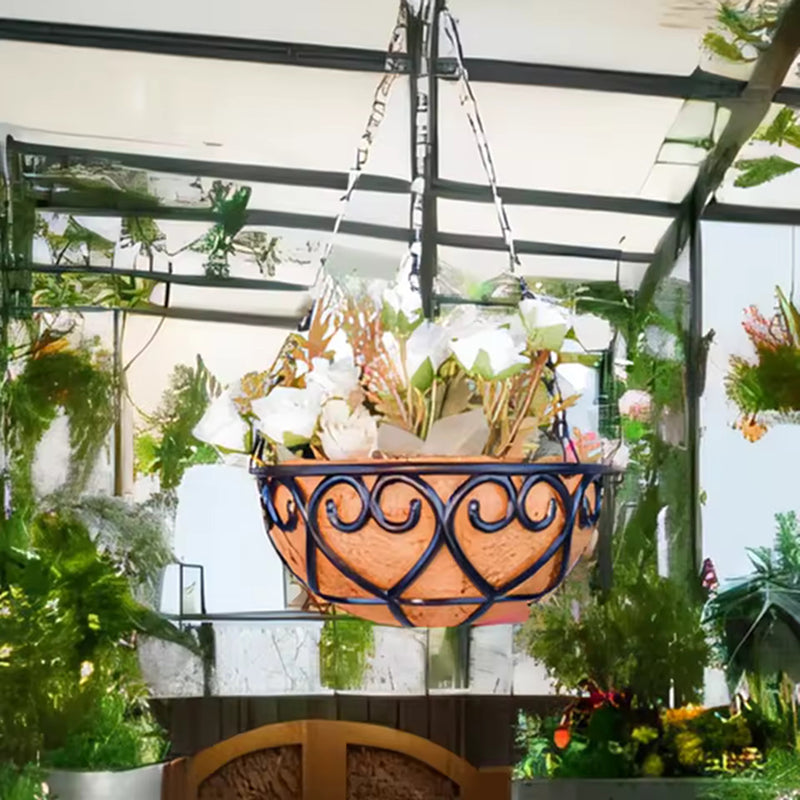 Decorative hanging basket with plants in a greenhouse setting