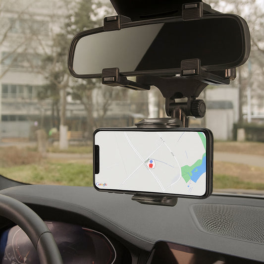 Phone mounted on a car dashboard with a map displayed, showing a rearview mirror above.