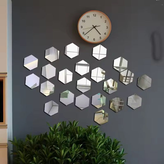 Hexagonal mirror stickers on a gray wall with a clock above them.