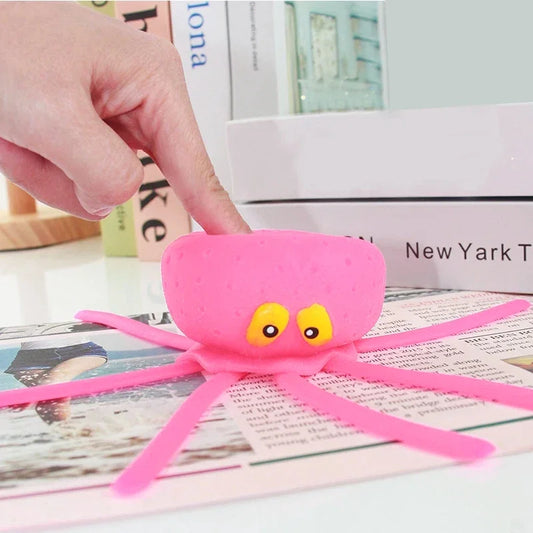 Pink octopus toy with a hand interacting with it on a newspaper background