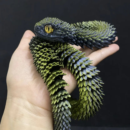 Green and black snake coiled around a person's hand against a dark background
