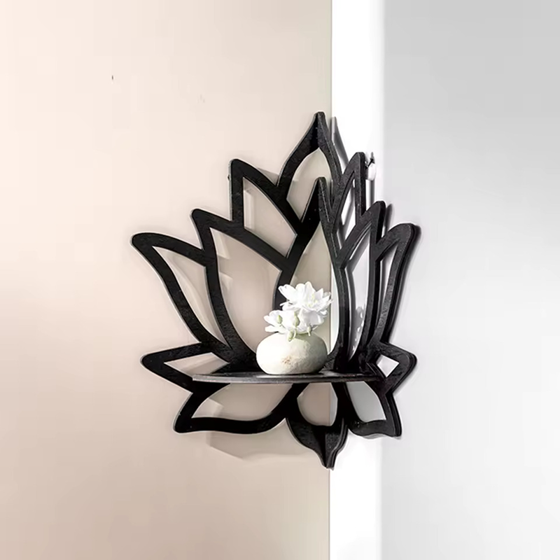 Black lotus-shaped wall mirror with a white decorative item on a neutral background