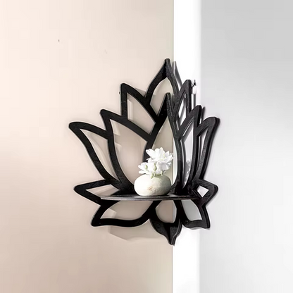 Black lotus-shaped wall mirror with a white decorative item on a neutral background