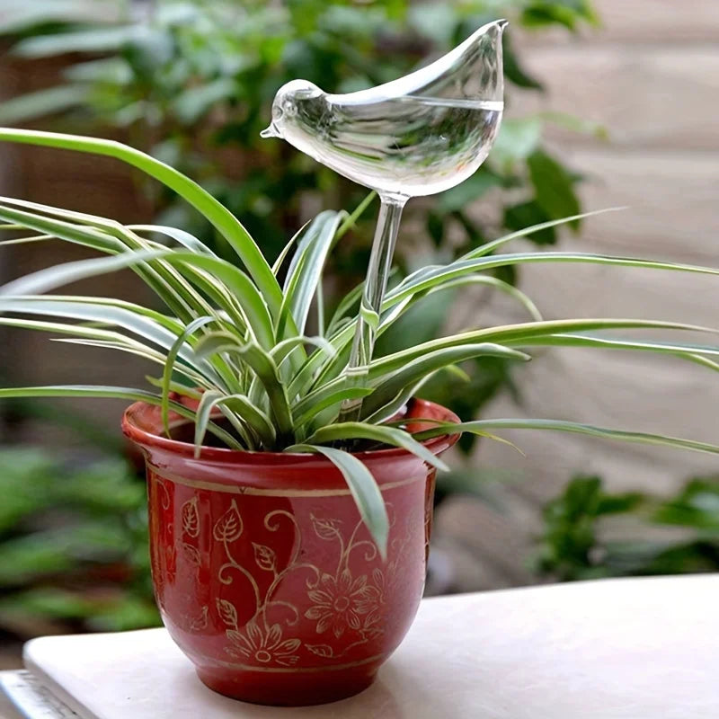 Potted plant with a decorative glass bird on a blurred green background
