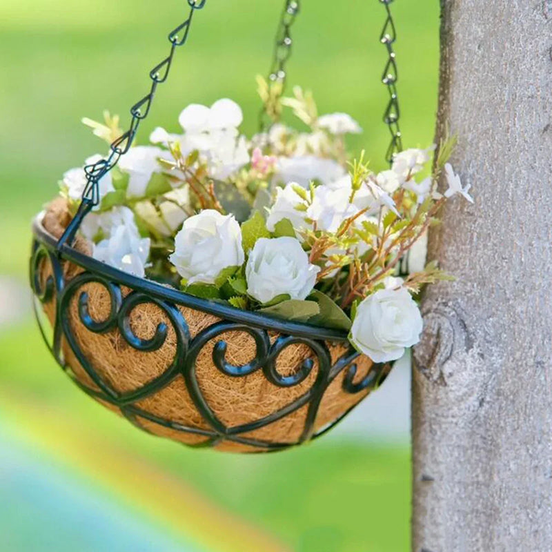 Decorative hanging basket with white flowers against a blurred green background