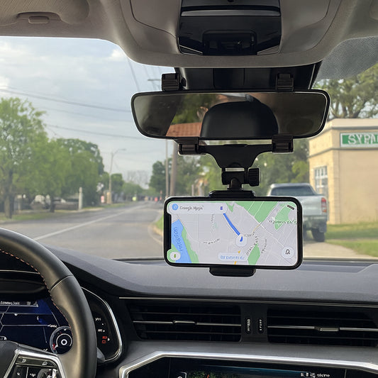 Phone mounted on a car dashboard displaying a navigation app with a road ahead.