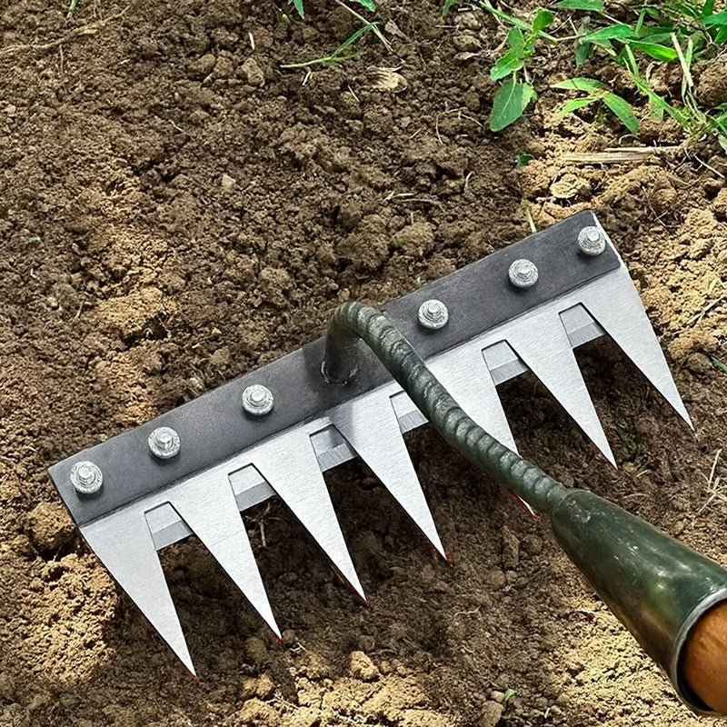 Garden tool with metal spikes on a soil background