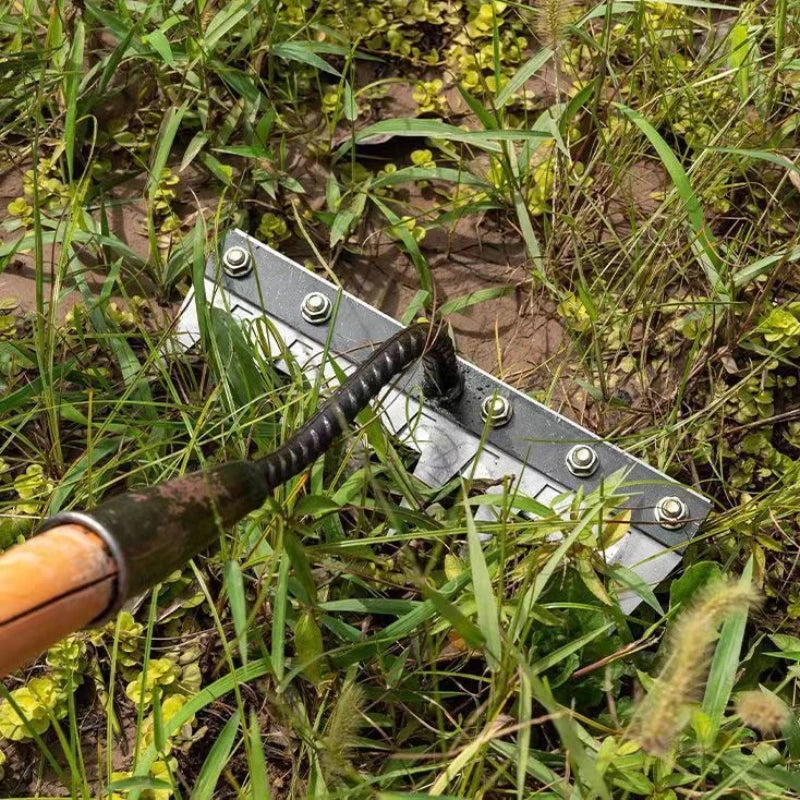 Metal tool with a black handle embedded in grass
