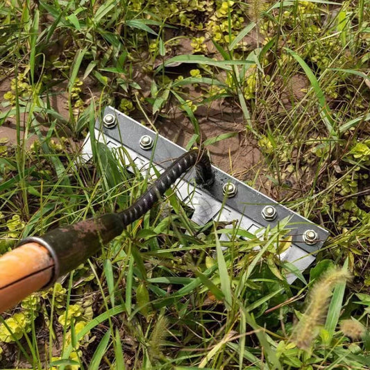 Metal tool with a black handle embedded in grass