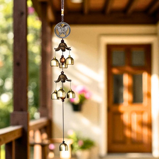 Decorative wind chime hanging in front of a wooden door with blurred background