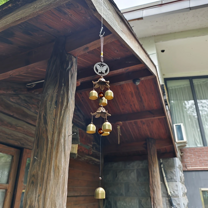 Decorative wind chime hanging from a wooden roof