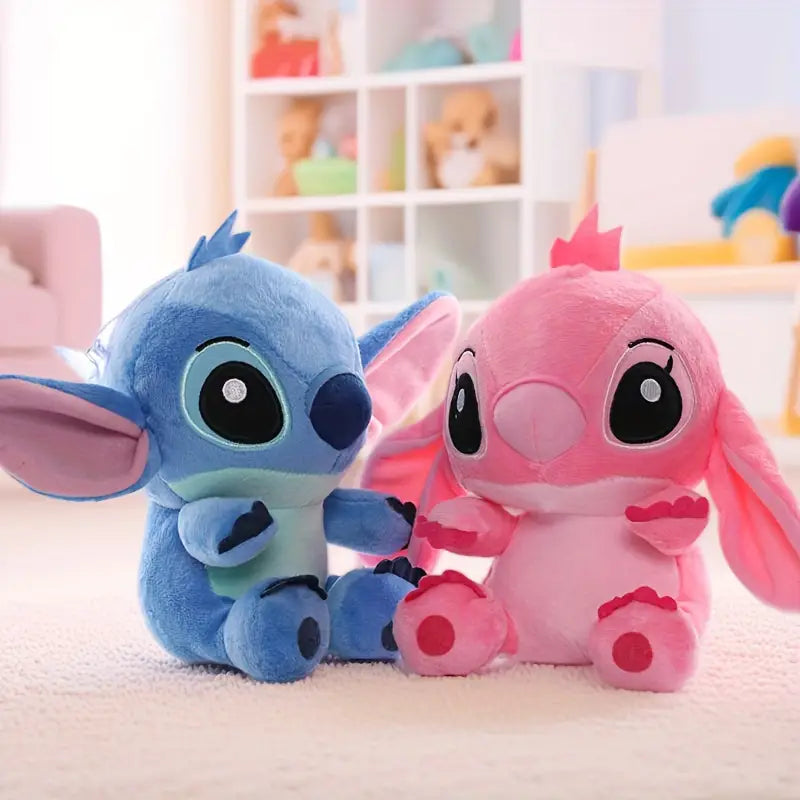 Two plush toys, one blue and one pink, sitting on a surface with a blurred background of toys.
