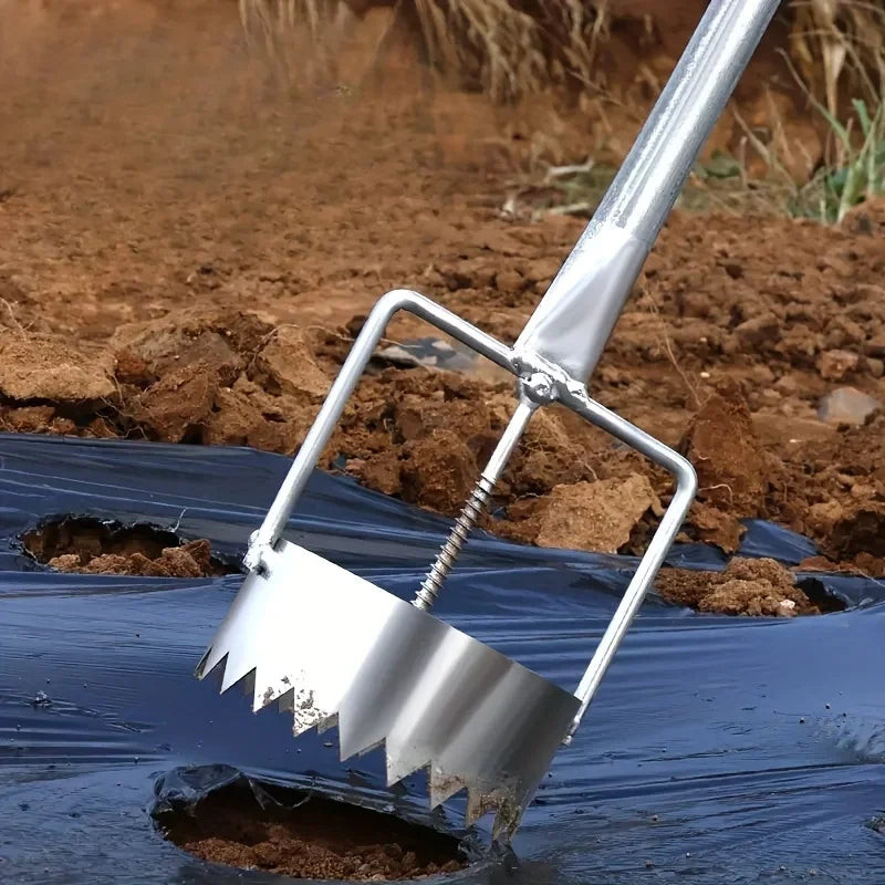 Metal tiller being used on a field with soil and black plastic sheeting.