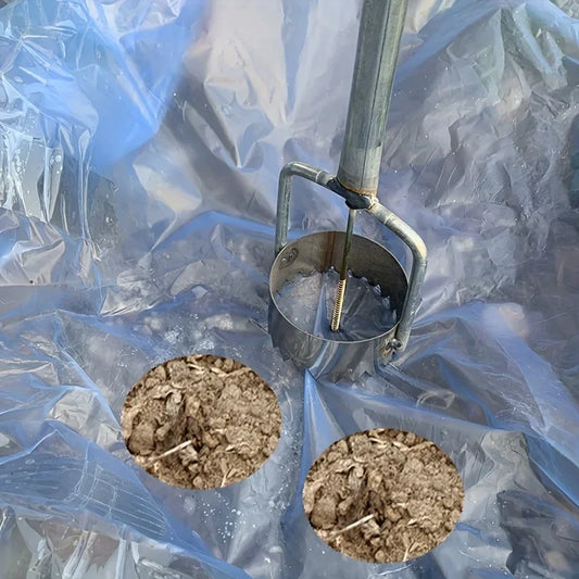 Metal seed drill with two holes filled with soil on a clear plastic background