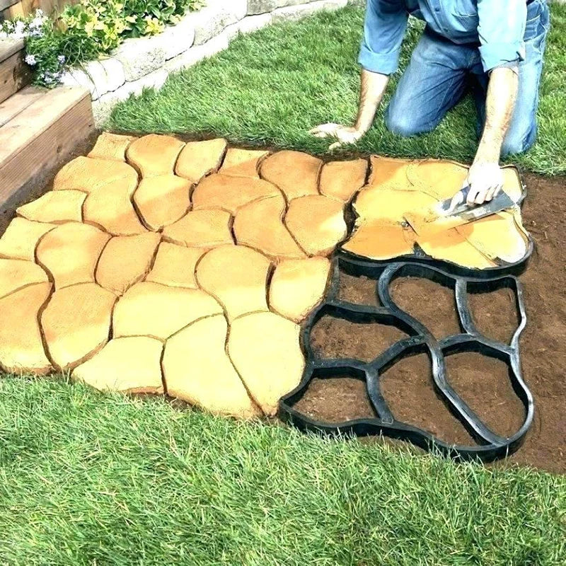 Person laying stone patio with a mold on grass