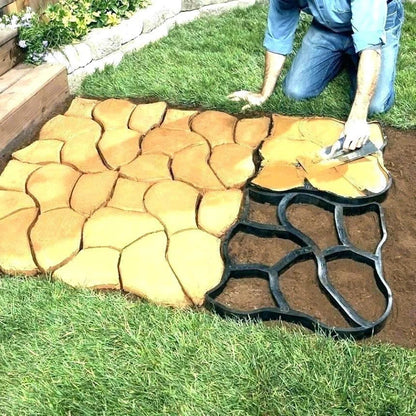 Person laying stone patio with a mold on grass