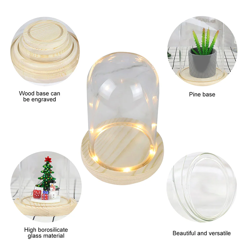 Glass dome with wooden base featuring a small Christmas tree decoration.