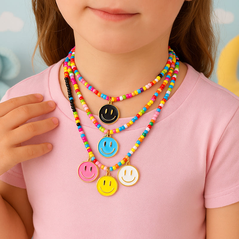 Child wearing a colorful beaded necklace with smiley face charms on a light pink shirt.