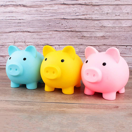 Three colorful piggy banks (blue, yellow, pink) on a wooden surface