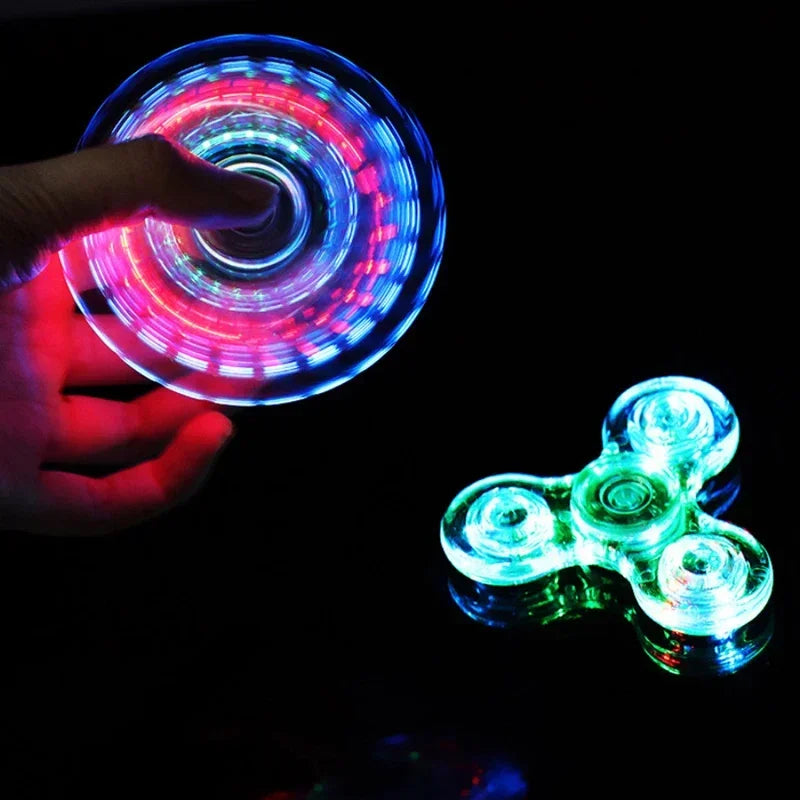 Hand holding a glowing LED spinner with another spinner on a black background