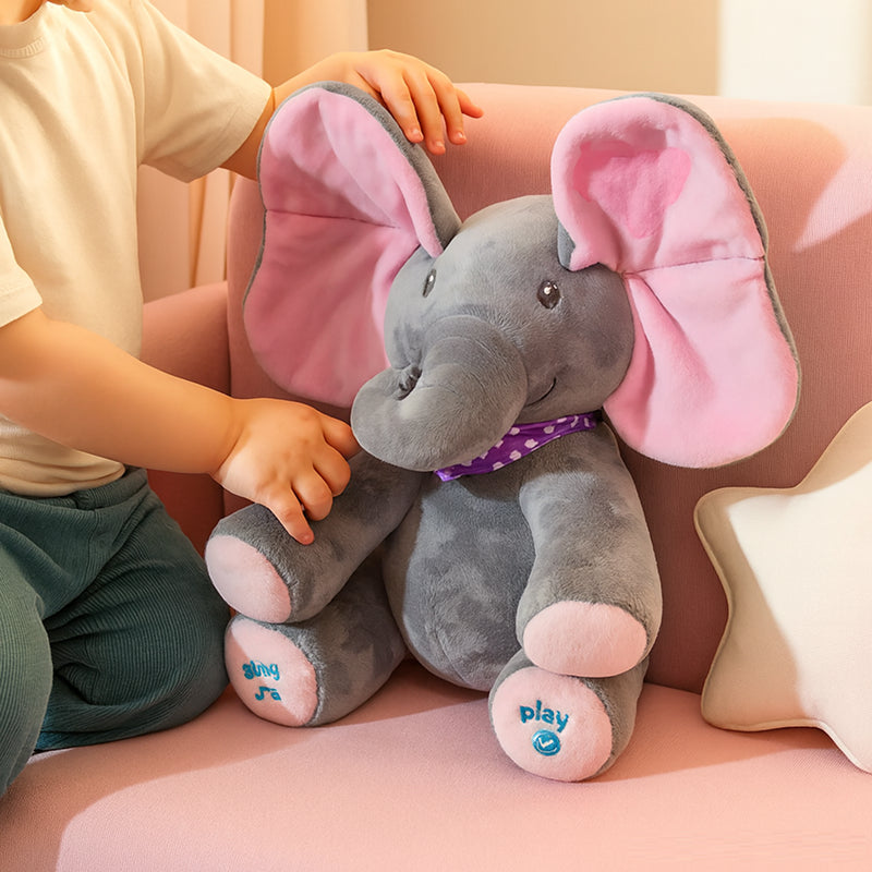 Child holding a plush elephant toy with pink ears on a pink couch.