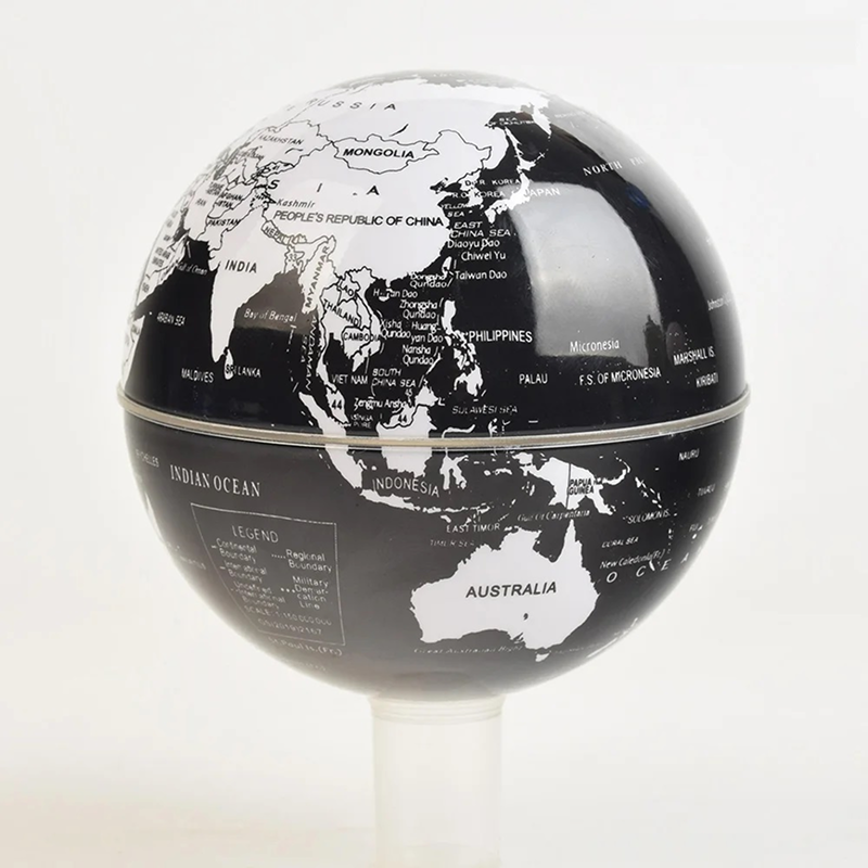 Black and white world globe on a stand with a light gray background