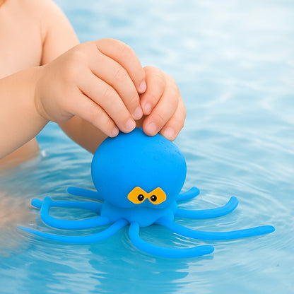 Child's hand holding a blue octopus toy in water