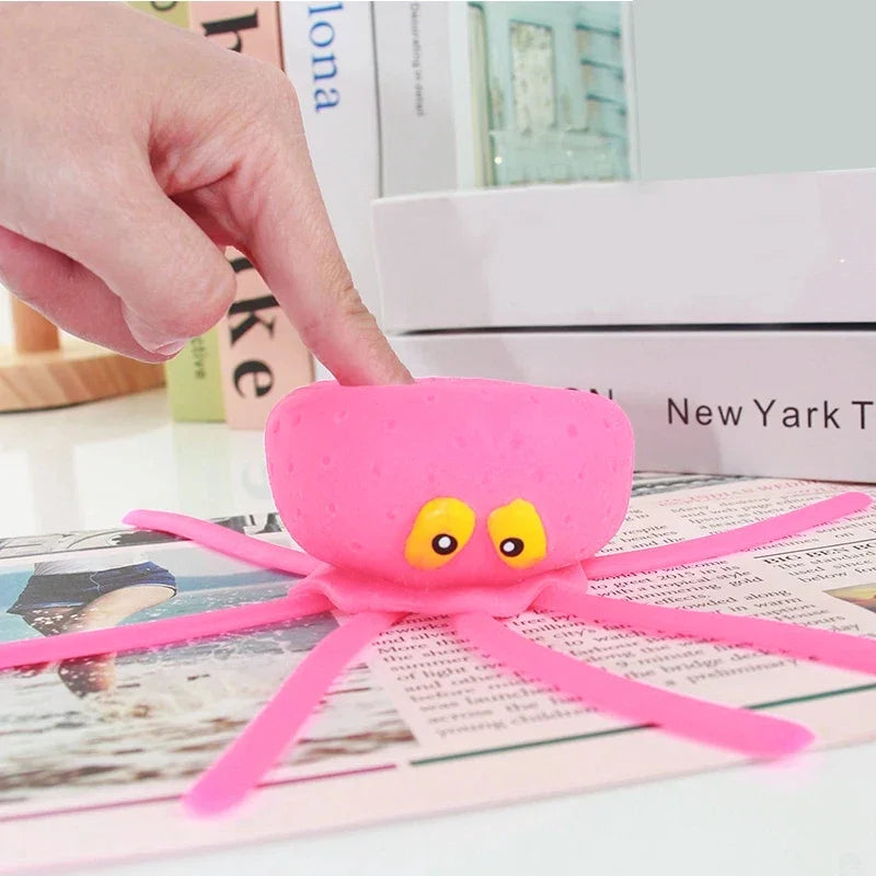 Pink octopus toy with a hand interacting with it on a newspaper background
