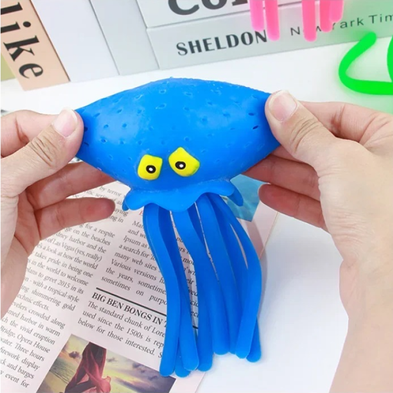 Blue octopus toy held by hands with a newspaper background