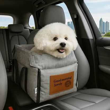 White dog in a gray pet seat carrier with 'Good morning! lovely' tag inside a car.