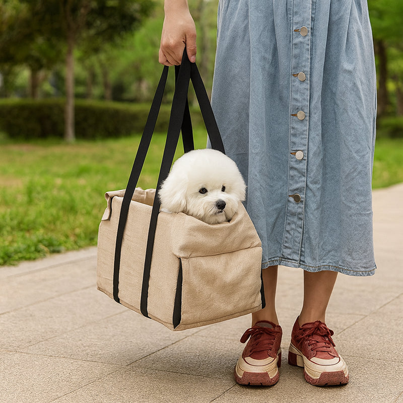 Person holding a beige pet carrier with a white dog peeking out, walking outdoors.