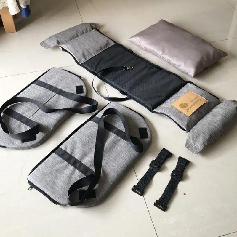 Gray and black travel pillow and straps on a light-colored floor