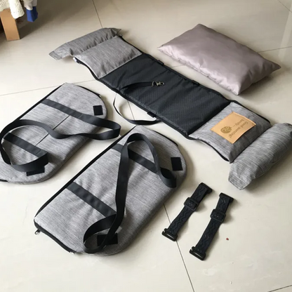 Gray and black travel pillow and straps on a light-colored floor