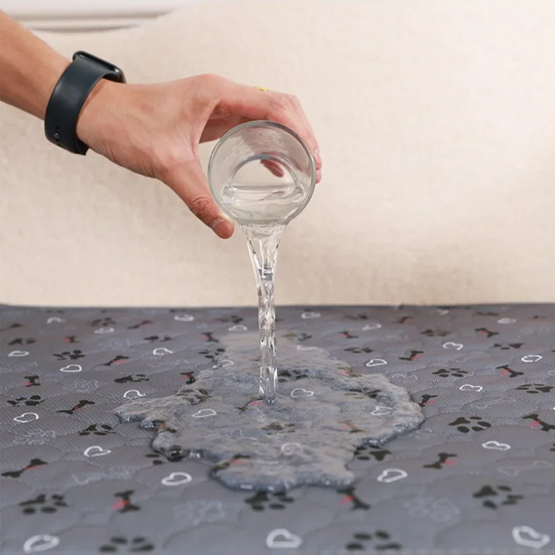 Person pouring water from a glass onto a patterned surface