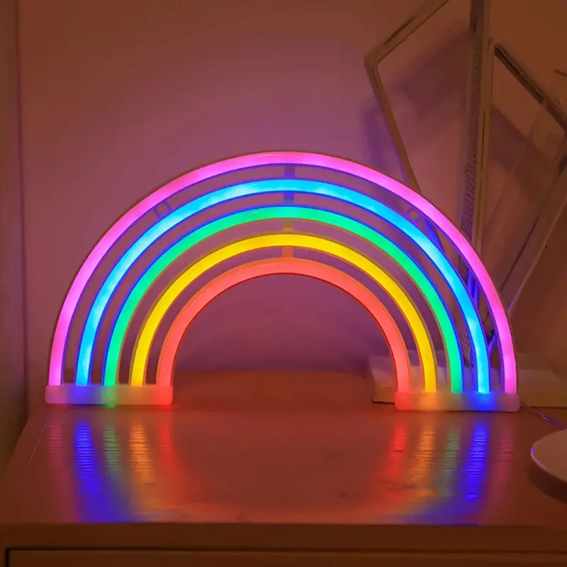 Neon rainbow light on a wooden surface with a soft pink background