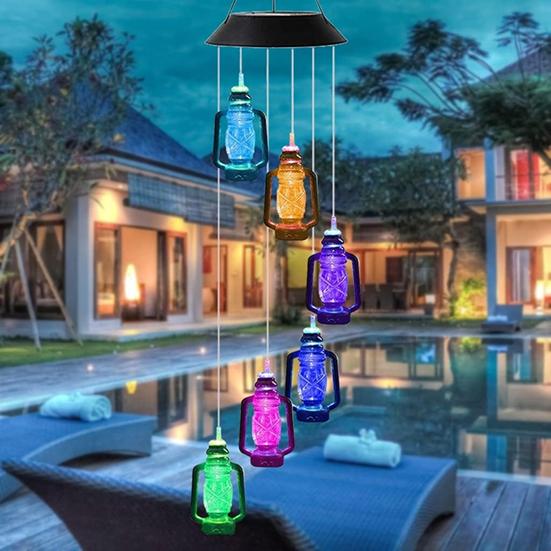Colorful solar-powered hanging lights in front of a pool and house.