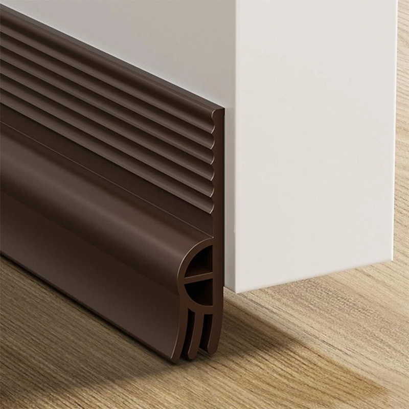 Brown door threshold strip on a wooden floor and white wall background
