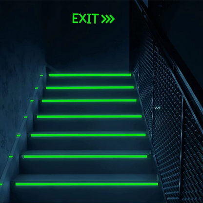 Staircase with green exit signs on a dark background
