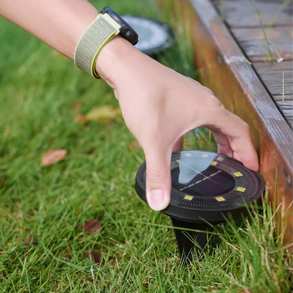 Person placing a solar-powered outdoor light on grass