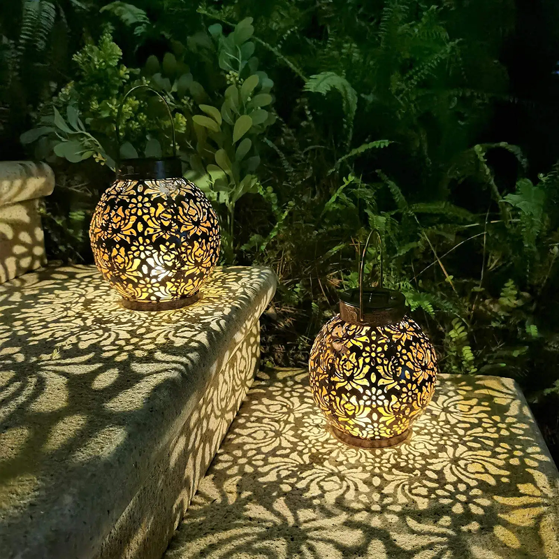 Decorative spherical lamps on a stone surface with greenery in the background