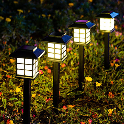Solar-powered garden lights on grass with flowers