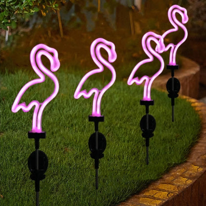 Four pink flamingo-shaped garden lights on grass