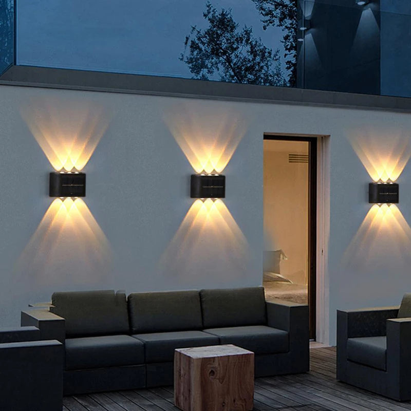 Modern outdoor living space with wall lights and a sofa.