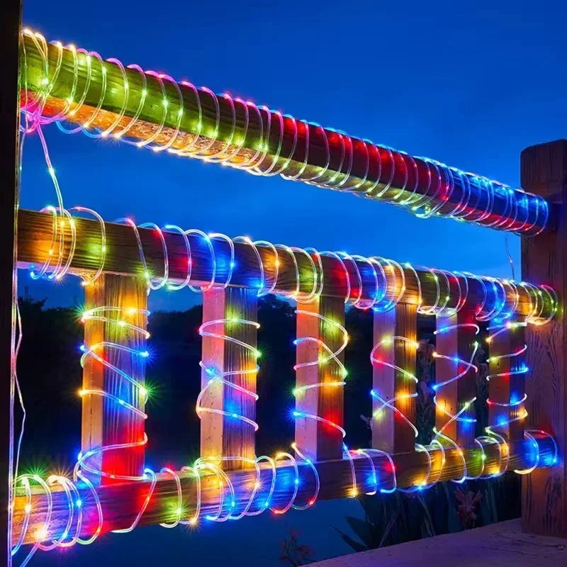 Colorful LED lights wrapped around a wooden fence against a dark sky