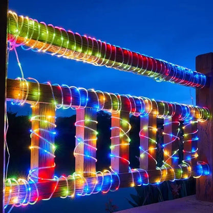 Colorful LED lights wrapped around a wooden fence against a dark sky