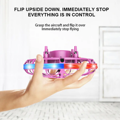 Hand holding a small pink and blue drone with text instructions on a white background