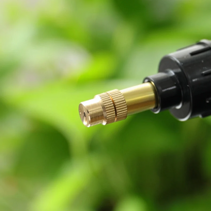 Close-up of a garden hose nozzle with a blurred green background