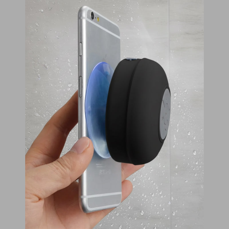 Hand holding a smartphone with a black and blue pop socket against a gray background