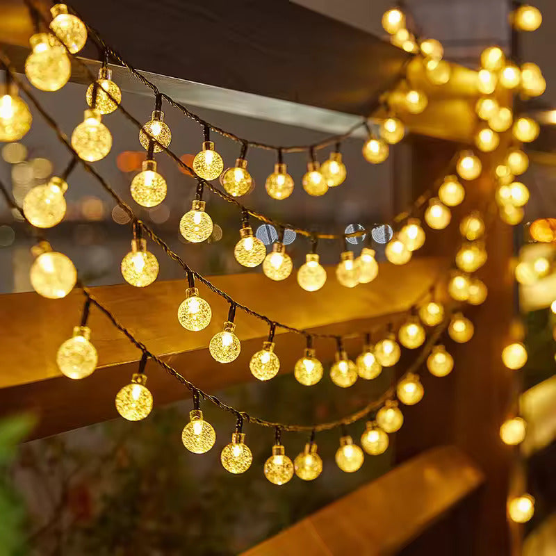 String of round lights hanging indoors with a blurred background
